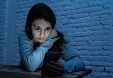 Siber zorbalık ve taciz acı akıllı cep telefonu üzücü korkmuş genç kadının dramatik portresi. Yalnız, depresif ve korku online Stalker tarafından istismar olma hissi. İnternet tehlikeleri.
