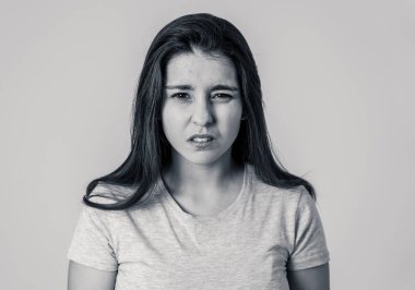Öfkeli yüzü olan genç çekici hayal kırıklığına uğramış beyaz bir kadının siyah beyaz portresi. Kızgın jestler yaparak kızgın ve üzgün görünüyor. Nötr arka plan. İnsan yüz ifadeleri ve duygular.