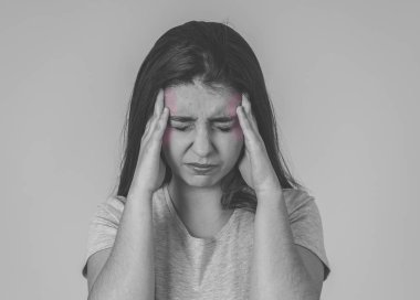 Siyah beyaz portresi genç üzgün bir kadın, ciddi ve endişeli, endişeli görünümlü ve düşünceli migren muzdarip. Nötr arka planda izole edilmiş. Yüz ifadeleri ve sağlık.