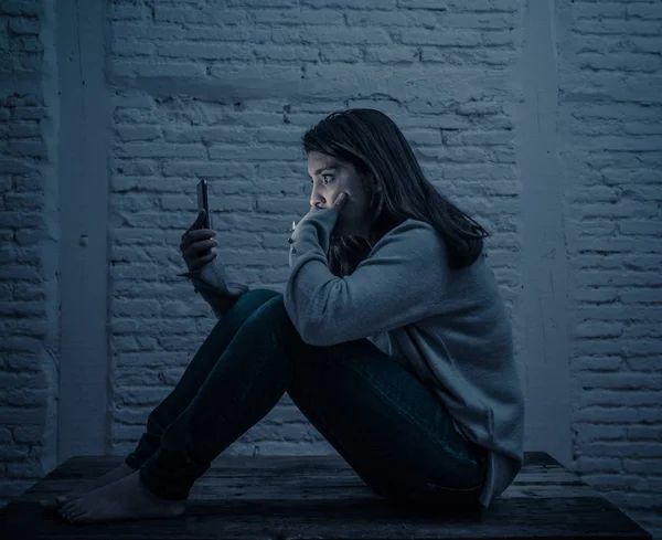 夜の床の上に悲しい怖がった若い女性の肖像は サイバーいじめの嫌がらせに苦しむスマート携帯電話を強調し 心配しています ストーカーによってオンライン虐待されることによって必死と落ち込んで — ストック写真