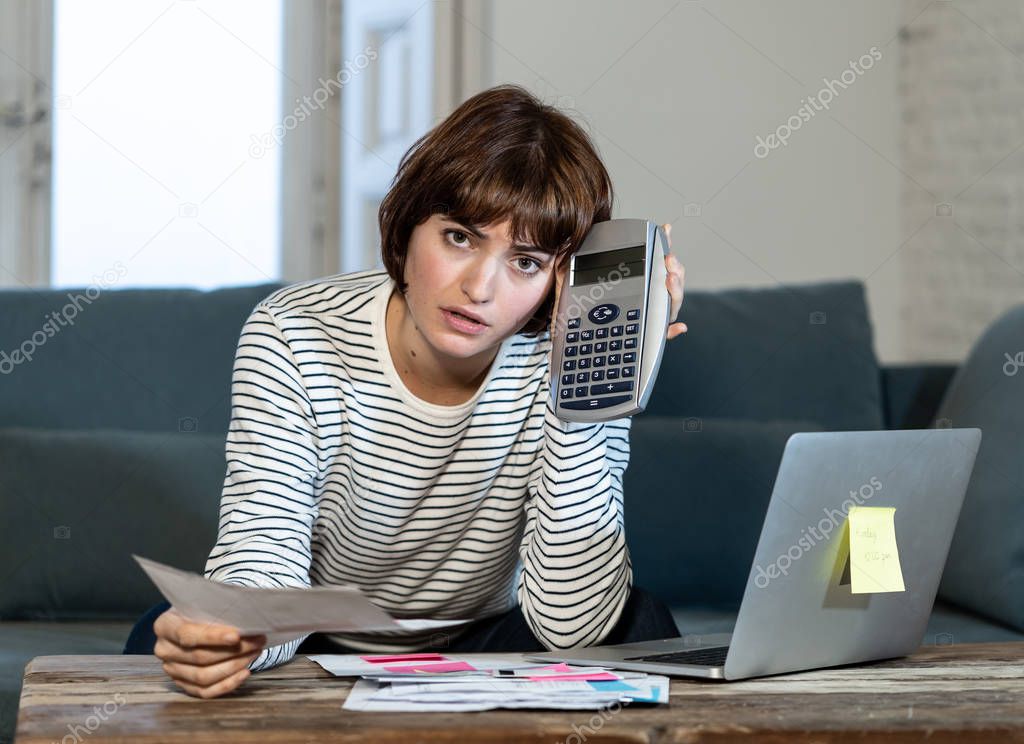 Worried and desperate young woman in stress accounting home or small business finances with too much debts and expenses. In online banking, paying bills mortgage and financial problems concept.