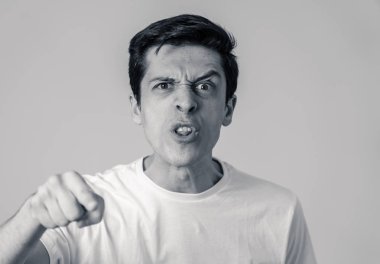 Siyah ve beyaz genç beyaz erkek yakın kadar öfkeli bir yüz. Deli ve çılgın bağırarak ve öfkeli jestler yapıyor. Beyaz arka planda izole edilmiştir. Yüz ifadeleri ve duygular.