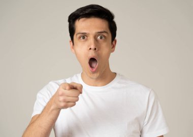 Bir sürpriz ve şok yüzü ile yakışıklı bir beyaz genç adam portre yakın. Çekici erkek geniş gözleri ve sürpriz açık ağız ile hayran bakıyor. İnsan yüz ifadeleri ve duygular.
