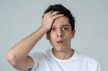 Ciddi ve endişeli, endişeli ve düşünceli görünümlü, Genç bir üzgün adam yakın. Baş ağrısı veya migreni ile ağrıyla başını dokunmadan. Kopya alanı ile. Yüz sağlık konsepti.