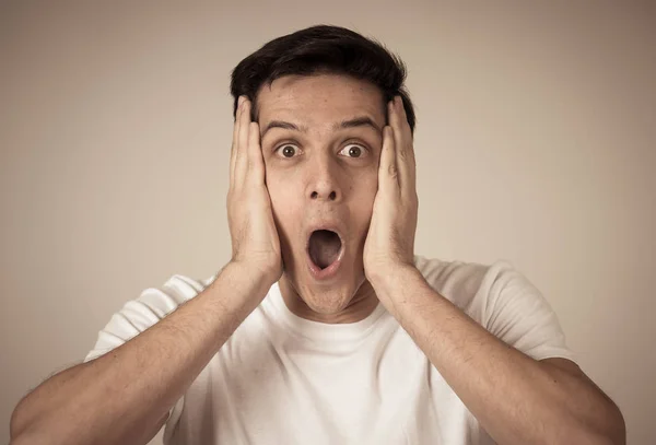 Portrait of young shocked man winning the lottery or having great success with surprised and happy face and gestures. In People, Facial Expression, Human Emotions and celebration. Studio shot.