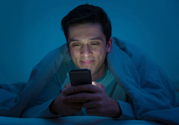 중독자 남자는 메시지를 보내는 스마트 침대에서 인터넷 미디어 네트워크 — 스톡 사진