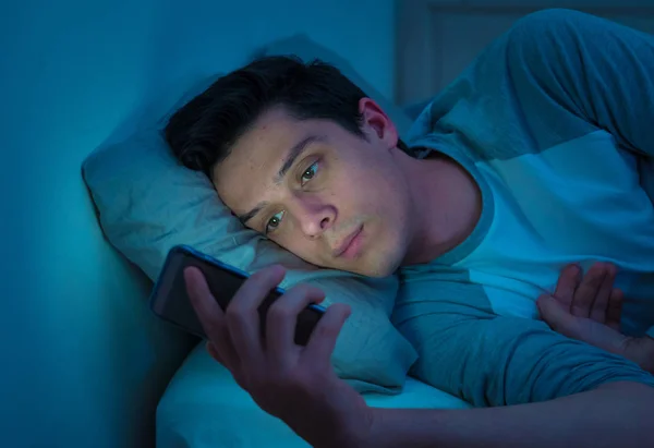 중독자 남자는 메시지를 보내는 스마트 침대에서 인터넷 미디어 네트워크 — 스톡 사진