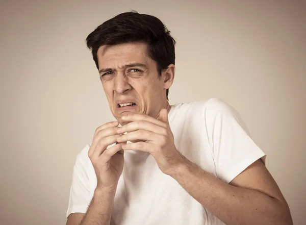 Young man feeling scared and shocked making fear, anxiety gestures. Looking terrified and desperate trying to cover himself. Portrait with copy space. People and Human expressions and emotions.