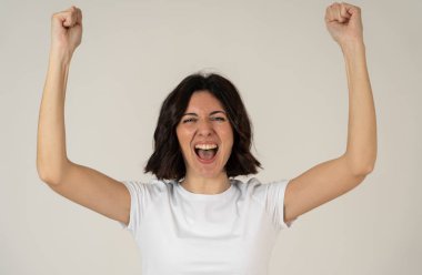 Sevinç bir jest mutlu yüzü ile güzel genç güzel beyaz kadın yakın portresi. Nötr arka planda izole edilmiş. İnsanlarda, olumlu insan yüz ifadeleri ve duygular kavramı.