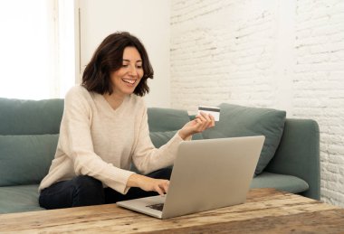 Kredi kartı ve dizüstü bilgisayar ile online alışveriş yapan çekici kadın. Mutlu internet moda ve satış, seyahat teklifleri ve gıda teslimat üzerinde giysi satın alma. E-ticaret ve teknoloji konseptinde
