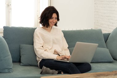 Bilgisayar dizüstü bilgisayar kullanarak çekici rahat kadın Lifestyle portre, online film izlerken zevk, sosyal medya tarama ve çalışma veya evde eğitim. İnternet teknolojisi ve ağ konseptinde.