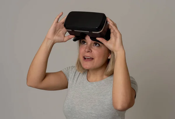 Curious woman happy and excited to use virtual reality goggles feeling excited about simulation, exploring virtual life making happy gestures. In New technology Virtual Augmented Reality concept.