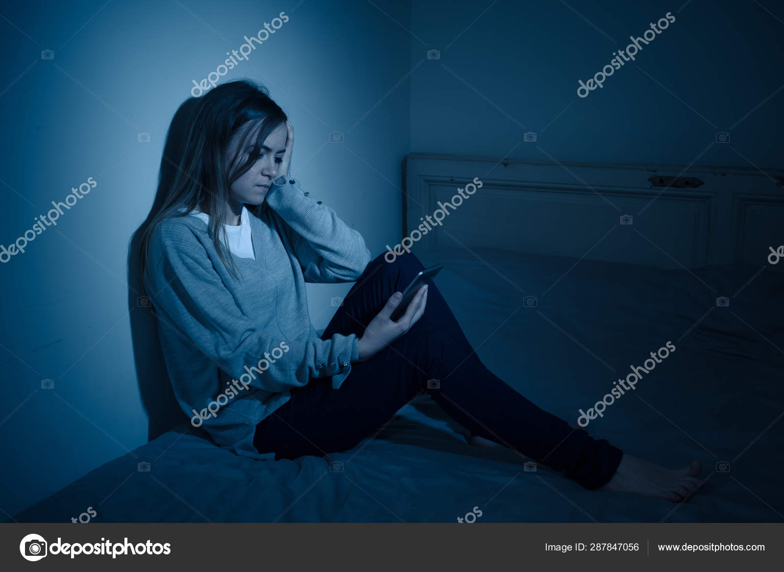 モバイル携帯電話中毒に苦しむ若いティーンエイジャーの女の子夜遅くにベッドに座っていることを必要とする不眠症を感じて寂しいと落ち込んでいます インチ ストック写真 C Samwordley Gmail Com