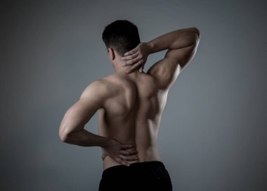 Genç Kas Fitness adam dokunmadan ve boyun ve alt sırt acı servikal ağrı nötr arka planda izole kapma. Spor ve egzersiz yaralanması, yanlış duruş sorunları ve vücut bakımı.