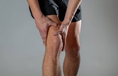 Genç fit adam kas yaralanması zarar kemik bacak ağrısı burkulma veya kramp çalışan egzersiz sırasında acı elleri ile diz tutarak. İçinde vücut ağrısı ve spor eğitim yaralanma ve vücut sağlık bakımı.