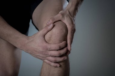 Genç fit adam kas yaralanması zarar kemik bacak ağrısı burkulma veya kramp çalışan egzersiz sırasında acı elleri ile diz tutarak. İçinde vücut ağrısı ve spor eğitim yaralanma ve vücut sağlık bakımı.