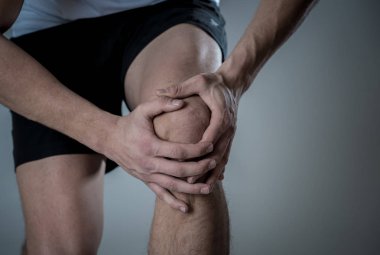 Genç fit adam kas yaralanması zarar kemik bacak ağrısı burkulma veya kramp çalışan egzersiz sırasında acı elleri ile diz tutarak. İçinde vücut ağrısı ve spor eğitim yaralanma ve vücut sağlık bakımı.