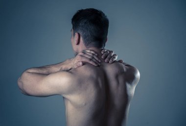 Genç kaslı uygun adam dokunmadan ve kapma boyun ve üst sırt acı servikal ağrı egzersiz sonra. Nötr arka planda izole. Spor yaralanması yanlış duruş sorunları ve vücut sağlık bakımı.