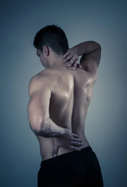 若い筋肉のフィットネスの男は 彼の首と腰の苦しみ中立の背景に隔離された子宮頸部の痛みに触れ つかむ スポーツやトレーニングの怪我では 不適切な姿勢の問題とボディケア — ストック写真