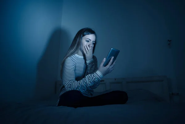 悲伤绝望的年轻少女在智能手机上遭受网络膨胀和骚扰 感觉孤独和绝望的晚上坐在床上 网络欺凌与网络概念的危害 — 图库照片
