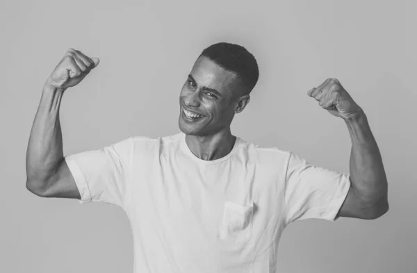 若い強いハンサムなアフリカ系アメリカ人男性は 楽しみを持って誇りに笑って腕の筋肉を示しています 人の中で フィットネス 人間の感情と表情の概念 — ストック写真