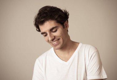 Mutlu, utangaç ve şanslı görünümlü sevgi genç hassas adam hissi portre yakın. Nötr arka planda izole. İnsanlarda olumlu insan duyguları, yüz ifadeleri ve vücut dili.