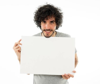 Komik ve iyi görünümlü milenyal adam gösteren ve metin için kopya alanı ile boş tahta işaret. Samimi ve heyecanlı genç şık adam reklam için boş poster tutuyor. Pazarlama konsepti.