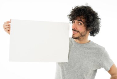 Komik ve iyi görünümlü milenyal adam gösteren ve metin için kopya alanı ile boş tahta işaret. Samimi ve heyecanlı genç şık adam reklam için boş poster tutuyor. Pazarlama konsepti.