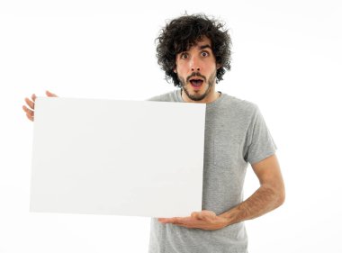 Harika bir ürün ya da şaşırtıcı satış veya büyük reklam gösterir gibi heyecanlı görünümlü metin için kopya alanı ile boş poster gösteren komik ve çekici milenyal adam. Stüdyo vurdu. Pazarlama konsepti.