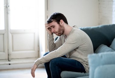 Mutsuz beyaz erkek oturan ve oturma odası kanepede yatarken depresif depresyonu yalnız bir acı duygu çaresiz. İş, anksiyete, kalbi kırık ve erkekler sağlık kavramı vurguladı içinde.