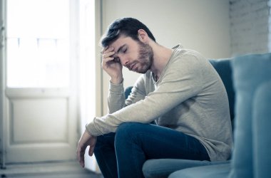 Mutsuz beyaz erkek oturan ve oturma odası kanepede yatarken depresif depresyonu yalnız bir acı duygu çaresiz. İş, anksiyete, kalbi kırık ve erkekler sağlık kavramı vurguladı içinde.