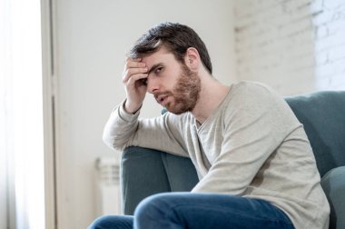 Mutsuz beyaz erkek oturan ve oturma odası kanepede yatarken depresif depresyonu yalnız bir acı duygu çaresiz. İş, anksiyete, kalbi kırık ve erkekler sağlık kavramı vurguladı içinde.