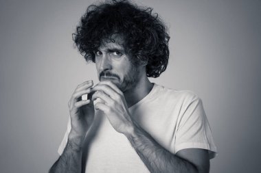 Genç adamın portresi, şiddet dolu bir sahnede ya da kokmuş ya da mide bulandırıcı bir şey. Nötr arka planda izole. İnsanlar ve ınsan ifadeleri ve olumsuz duygular.