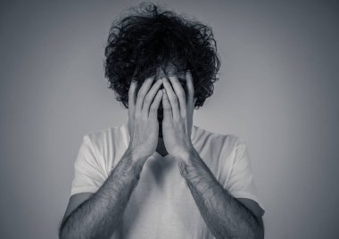 Genç üzgün adamın portresi, endişeli ve endişeli, depresif ve umutsuz görünümlü. Üzüntü ve korku hissi. Beyaz kopya alanı ile. Insanlar, yüz ifadeleri ve duygular ve ruh sağlığı kavramı.