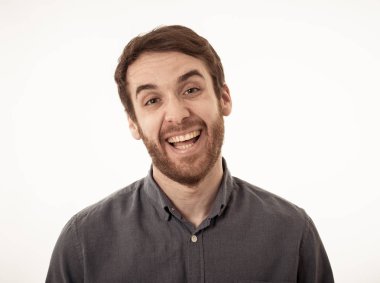 Mutlu yüz güzel gülümseme ve mavi gözleri ile çekici genç model portre. 20 ' li yaşlarda yakışıklı hipster sakallı adam. Stüdyo çekimi. Insanlar, moda ve insan yüz ifadeleri ve duygular.