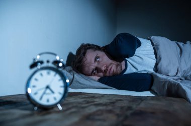 Uykusuzluk stres ve uyku bozukluğu kavramı. Uykusuz umutsuz Genç beyaz adam uykusunda uyku mümkün değil, sinirli ve endişeli görünümlü endişe ve alarm saati endişe hissediyorum.