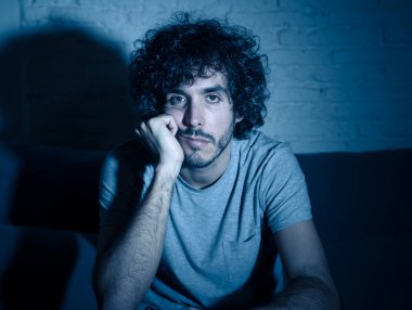 Başka bir film veya gece geç saatlerde göstermek için TV uzaktan kumanda zap kullanarak kanepede genç sıkılmış adam. İlgilenmiyor ve uykusuz görünüyorsun. Eğlence Insanlar uykusuzluk ve sedanter yaşam tarzı kavramı.