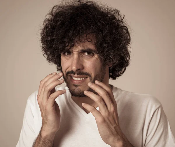 Portrait of young man feeling disgusted and shocked at some violent scene or smelling or disgusting thing. Isolated on neutral background. People and Human expressions and negative emotions.