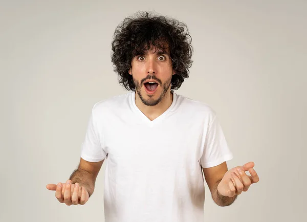 Portrait of funny attractive young man with happy and surprised face pointing and looking excited at something shocking and good. Human emotions, facial expressions. Advertising, sales or winning.