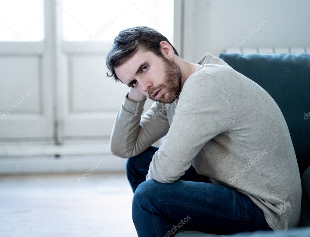Unhappy depressed caucasian male sitting and lying in living room couch feeling desperate a lonely suffering from depression. In stressed from work, anxiety, heartbroken and men Health care concept.