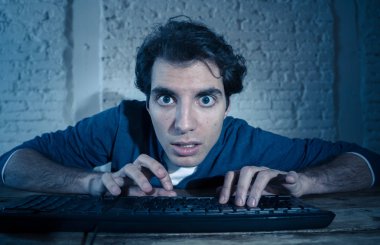 Bilgisayar laptop çalışma, online kumar, porno izlerken veya evde geç veya internet sohbet sosyal medya ağı kullanarak oyun oynarken tek başına gece yalnız bağımlısı genç adam. Teknoloji bağımlılığı.