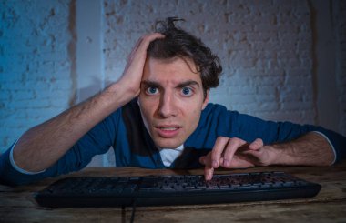 Bilgisayar laptop çalışma, online kumar, porno izlerken veya evde geç veya internet sohbet sosyal medya ağı kullanarak oyun oynarken tek başına gece yalnız bağımlısı genç adam. Teknoloji bağımlılığı.