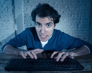 Bilgisayar laptop hissi geceleri yalnız bağımlısı genç adam vurguladı ve iş bitirmek veya online oyun veya kumar kazanmak için çalışırken boğulmuş. İşkolik ve internet teknolojisi bağımlılığı.