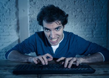 Bilgisayar laptop hissi geceleri yalnız bağımlısı genç adam vurguladı ve iş bitirmek veya online oyun veya kumar kazanmak için çalışırken boğulmuş. İşkolik ve internet teknolojisi bağımlılığı.