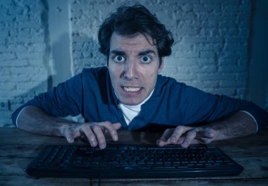 Bilgisayar laptop hissi geceleri yalnız bağımlısı genç adam vurguladı ve iş bitirmek veya online oyun veya kumar kazanmak için çalışırken boğulmuş. İşkolik ve internet teknolojisi bağımlılığı.