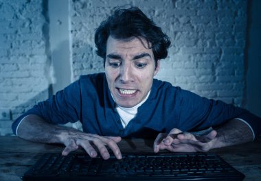 Bilgisayar laptop hissi geceleri yalnız bağımlısı genç adam vurguladı ve iş bitirmek veya online oyun veya kumar kazanmak için çalışırken boğulmuş. İşkolik ve internet teknolojisi bağımlılığı.