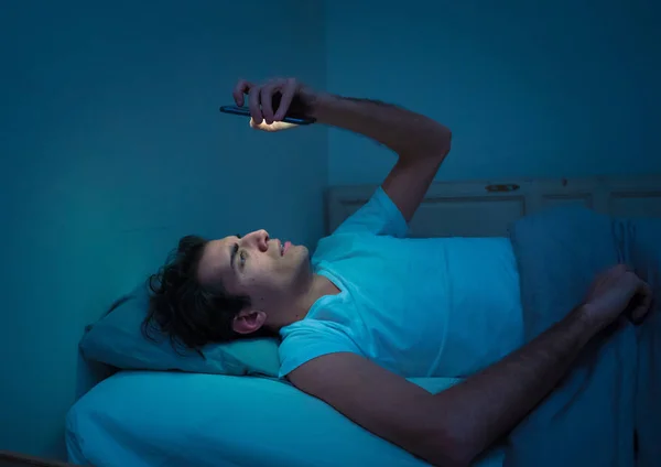 침대에서 스마트 인터넷 스러운 빛으로 어두운 방에서 불면과 불면증과 모바일 — 스톡 사진