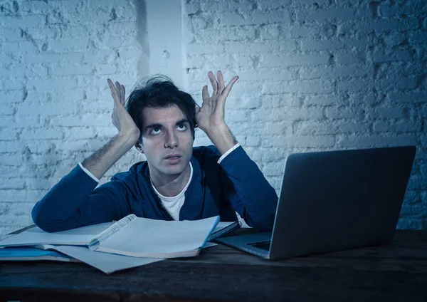 Aşırı çalıştı ve stresli genç öğrenci laptop duygu sıkıntılı yorgun endişeli ve üzücü yoruldu gece geç saatlere kadar sınava hazırlanıyor. Moody koyu ışık. Online öğrenme, üniversite eğitimi ve stres.