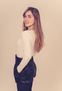 Uzun sarışın saçlı ve güzel gülümsemesi ile genç güzel genç kadın yarı uzunlukta stüdyo portre. Kendine güvenen, rahat ve güzel poz ve modelleme Feeling. Insanlar yaşam tarzı ve gençlik güzelliği.