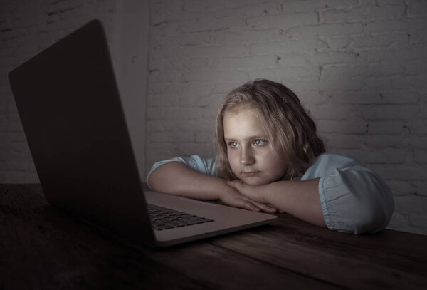 Scared sad girl bullied online on laptop suffering cyber bullying harassment. School girl humiliated on the internet by classmates feeling desperate and intimidated. Children victim of bullying.